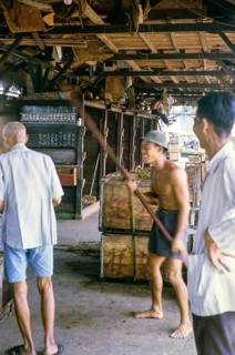 Workers having fun at store ice building at the fish market, East coast, Mersing, Johor, Malaya,