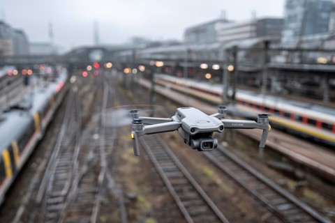 Ein Fernpilot steuert sein Quadrocopter, Drohne illegal über Bahnhofsgelände, Bahngelände,
