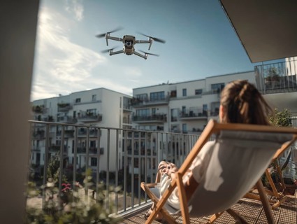 Ein Fernpilot steuert sein Quadrocopter, Drohne in einem dicht besiedeltem Wohngebiet und nähert