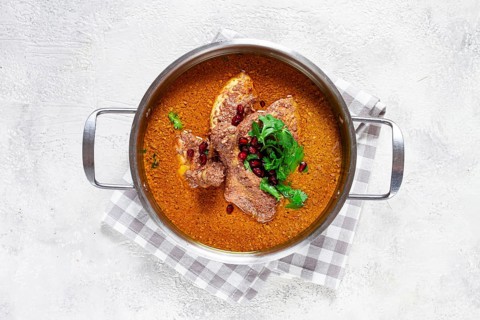 Fesenjan, an Iranian dish, stewed chicken, in a nut-pomegranate sauce, in a saucepan, light