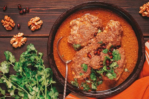 Fesenjan, an Iranian dish, stewed chicken, in walnut-pomegranate sauce, in an earthen pan,