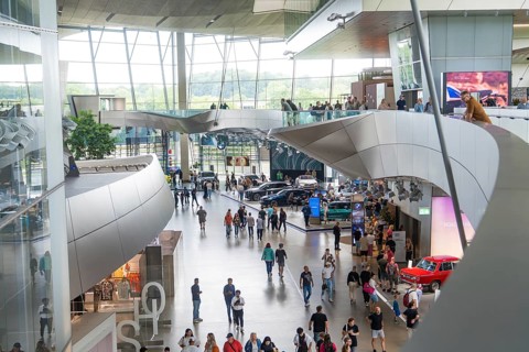 Modern interior with people and exhibited cars in a light-flooded environment, BMW Welt, Munich,