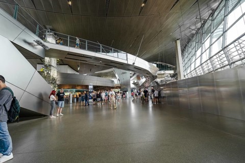 Large interior with modern architecture and people walking through the space, BMW Welt, Munich,