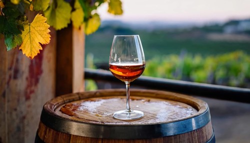 Glass of 10-year-old tawny wine placed on a barrel in a vineyard restaurant, AI generated
