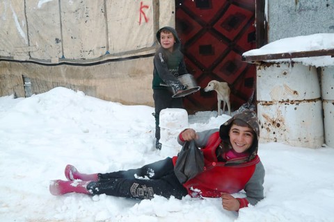 Displaced Syrian families and children living in refugee camps during harsh winter conditions,