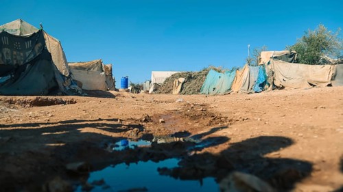 Worn-out tents housing Syrian refugees near the Turkish border, showing the dire humanitarian