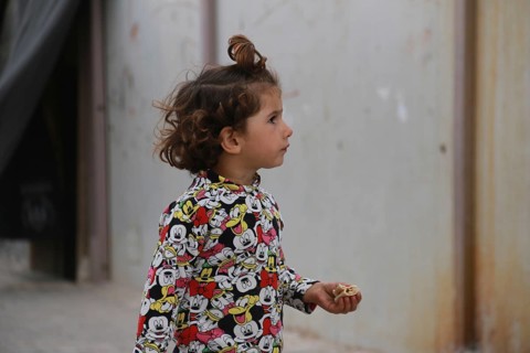 A Syrian refugee child photographed in a camp, reflecting the harsh living conditions of displaced