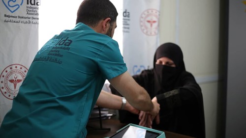 A doctor examining a woman inside a mobile medical point dedicated to treating Syrian refugees.