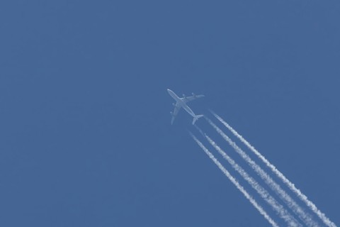 Airbus A340-300 jet aircraft of Lufthansa airlines in flight in a blue sky with vapour trails or
