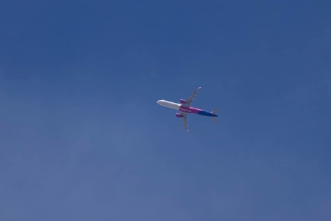 Airbus A321 jet aircraft of Wizz Air airlines in flight in a blue sky, England, United Kingdom