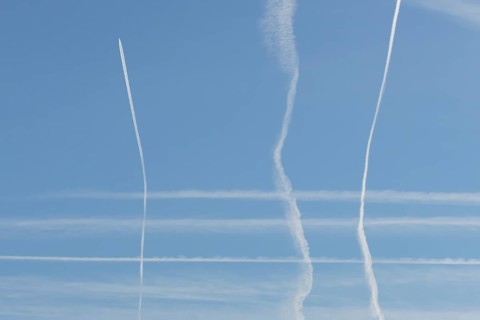 Jet aircraft vapour trails or contrails in a blue sky, England, United Kingdom