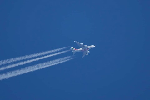 Airbus A380 jet passenger aircraft of Emirates airlines flying with vapour trails or contrails
