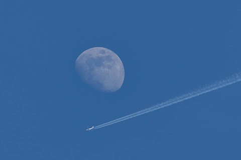 Boeing 737 jet passenger aircraft of Norweign Air with a vapour trial or contrail behind flying in