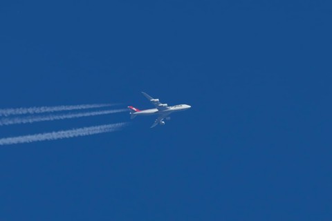 Boeing 747 jumbo jet cargo aircraft of Cargolux airlines with a vapour trail or contrail flying in