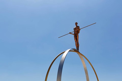 Sculpture Balance by the artist Martina Ondáková in front of a blue sky, human figure balanced,