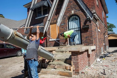 Detroit, Michigan, Workers rebuild front porch of a house they are remodeling in the Morningside