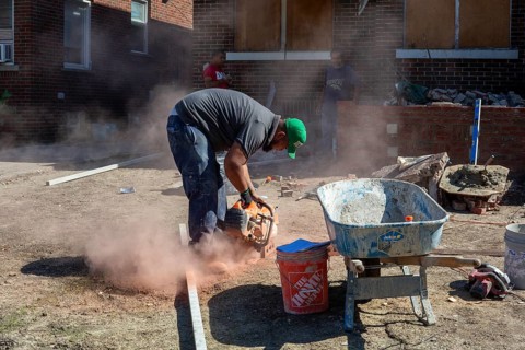 Detroit, Michigan - Workers rebuild the front porch of a house they are remodeling in the