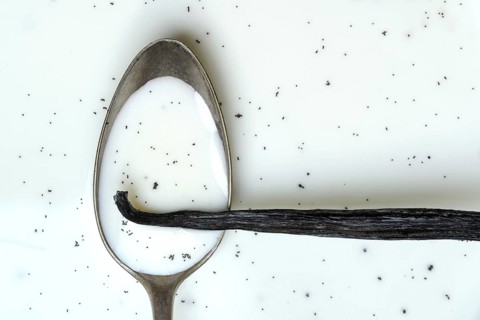 Spoon with vanilla pod, vanilla seeds in milk