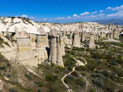 Panorama of imposing rocks and cliffs with a winding path in sunny surroundings, aerial view,
