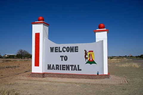 Sign with town coat of arms at the entrance to Mariental, Hardap Region, Namibia