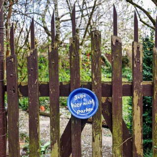 Funny sign at the old garden gate, blue plate with inscription, Please do not park here, Hanover,