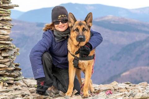 Woman and her German Shepherd sitting on a mountain top, Gaspesie Region, Province of Quebec,