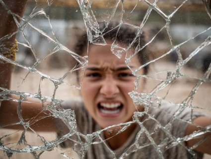 Ein Teenager schreit wütend durch eine kaputte Fensterscheibe, Aggressives Verhalten, Psychologie,