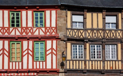 Two half-timbered houses in contrasting colours, windows with green frames, Tréguier, Brittany,