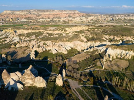 Vast landscape with hills and unique rock formations in the sunlight, aerial view, Göreme National