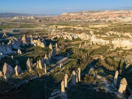 Aerial view of a rocky landscape in Cappadocia with striking rock formations and valleys under a