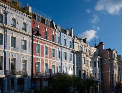 Terraced houses, townhouses with different, colourfully painted facades under a blue sky,