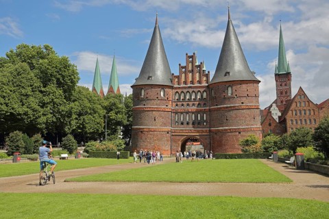 Historic Holsten Gate and pedestrians, tourists, photograph, St. Mary's Church, Lübeck St. Peter's