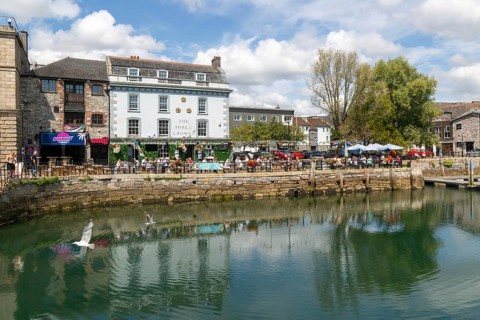 People sitting outside The Three Crowns pub quayside harbour, The Barbican, Plymouth, Devon,