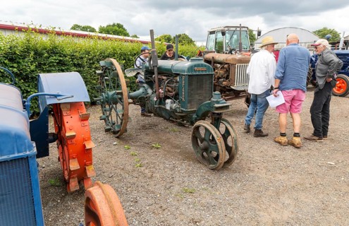 People viewing vintage Fordson tractors on display at auction, UK