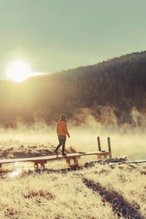 Young woman at Lake Staz near Sankt Moritz in the Engadine in Switzerland. Morning atmosphere with
