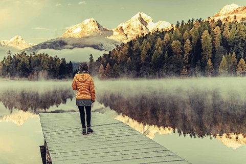 Young woman at Lake Staz near Sankt Moritz in the Engadine in Switzerland. Morning atmosphere with