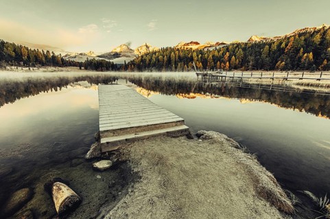 Lake Staz near Sankt Moritz in the Engadin in Switzerland. Morning atmosphere with fog in autumn.