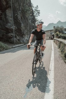 Young man riding a racing bike on Lake Garda. Sunny weather and dolce vita