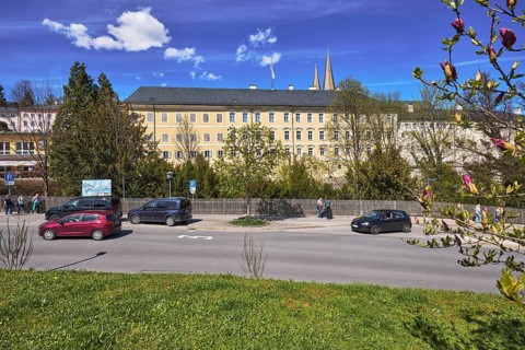 Royal Castle Berchtesgaden, general development, lawn, parking lane with vehicles, wooden fence,