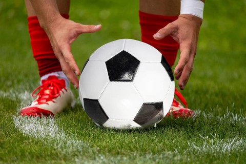 (Photomontage, ball replaced) Footballer prepares the ball for a corner kick
