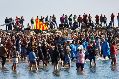 Pilgrimage, procession by the sea, pilgrims walking through water, statue of the Virgin Mary,