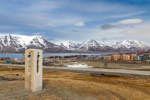 Statue by Nico Widerberg, view of Longyearbyen, coloured wooden houses, mountain range,