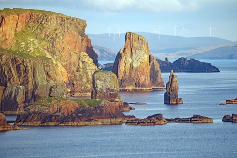 Dramatic coastal landscape with high cliffs, wind turbines and calm sea, Eshaness, Shetland