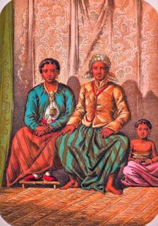 Seated Javanese family with father, mother and child, traditional clothing, headscarf, jacket, long