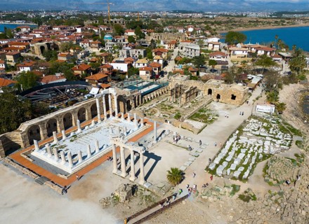 Ancient ruins next to a town overlooking the sea. Historical and scenic scenery, aerial view,