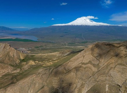 Snow-covered mountain under a clear blue sky with a vast landscape in the foreground, Great Ararat,