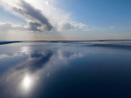 Fascinating lake landscape with calm water that reflects the sky and clouds, radiates peace and