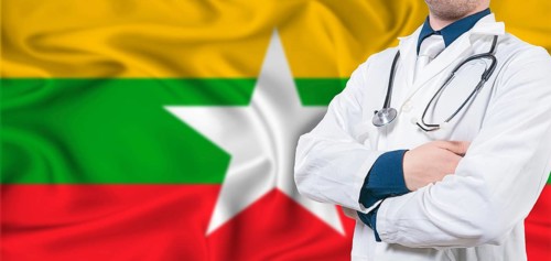 Myanmar healthcare concept. Male doctor on Myanmar flag. Doctor with crossed arms on Myanmar flag