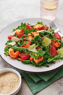 Fresh shrimp salad with arugula, grapefruit, and parmesan served in a bowl