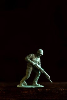 A small soldier figure stands ready with a rifle, capturing the essence of military readiness and